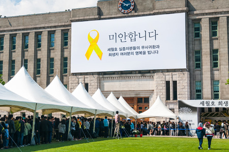 A long queue of visitors wait outside City Hall to pay their respects to the victims of the Sewol...
