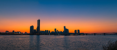 The sun sets behind the skyscrapers of Seoul, South Korea.の写真素材
