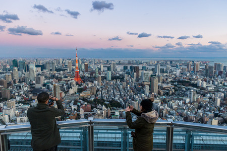 Tourists snap photos of Tokyo Tower from atop Mori Tower on January 2, 2015 in Tokyo, Japan.のeditorial素材