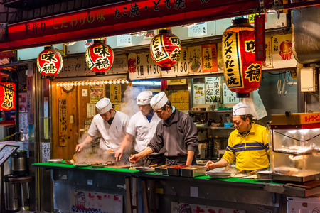 Men cook traditional Japanese street food on December 27, 2014 in Osaka, Japan.のeditorial素材