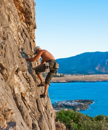 climber while climbing a vertical rock wallの写真素材