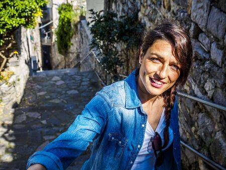 beautiful girl wolking in the National park of Cinque Terre in Liguria, Italy, looking through the lens.の写真素材