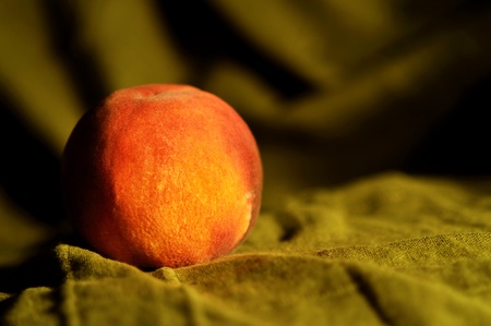 single peach on green material backgroundの写真素材