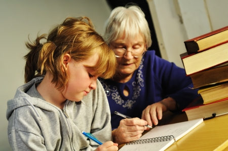 A senior woman helping a girl with her homeworkの写真素材