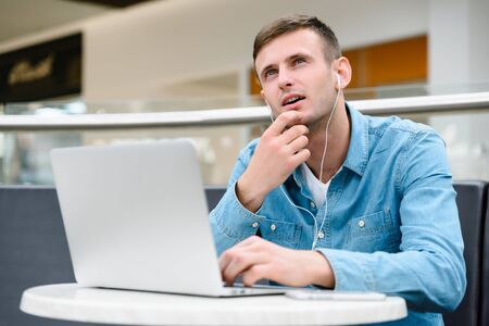 man working at a computer with headphones