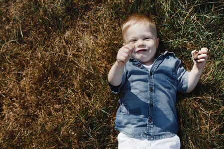 Portrait of a little boy lying on the grass
