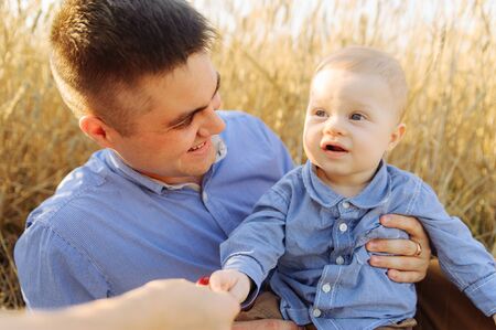 Portrait of the father and his small son in the blue shirt. Walking outsideの写真素材