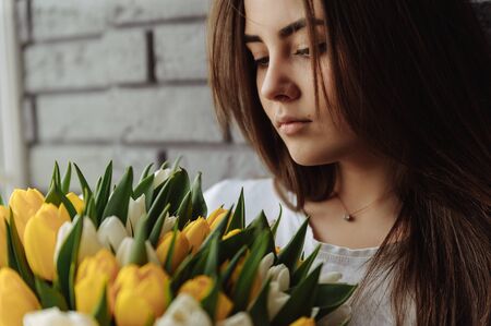 Girl looking on the bouquet of tulipsの写真素材