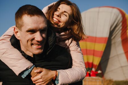 Smiling couple in love on the background of the hot air balloon. Husband and wifeの写真素材