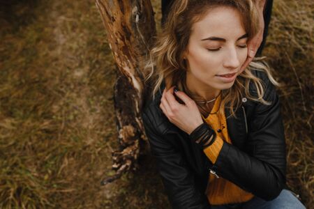 Woman sitting with closed eyes on the grass. Woman portrait
