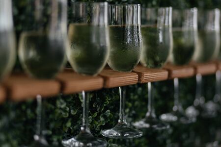 Glasses of champagne on the wooden stand. Alcohol drink. Champagne