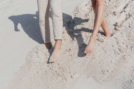 Happy young couple walking on the sand. Couple legs. Love storyの写真素材