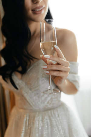 Bride holding the glass of champagne in her hand. Faceless bride. Bridal morningの写真素材
