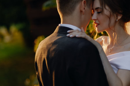 Beautiful newlyweds are hugging in the park at sunset. Close-up. Place for your text. High quality photoの写真素材