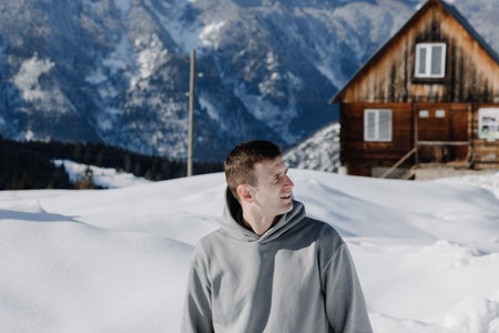 Portrait of a young guy against the backdrop of snow-capped mountains. Winter holidays, active...