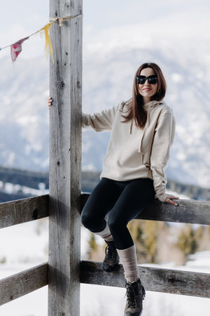 Stylish attractive young smiling woman sitting on the terrace and looking at the camera on the...