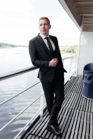 Confident and successful. Full height handsome young man looking to the side while standing on...