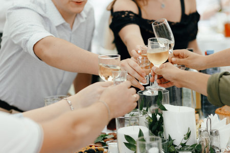Hands holding glasses and toasting, happy festive moment, luxury celebration concept. Clinking glasses of champagne in handsの写真素材
