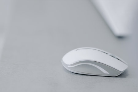 White bluetooth mouse for computer on a gray table. High quality photo