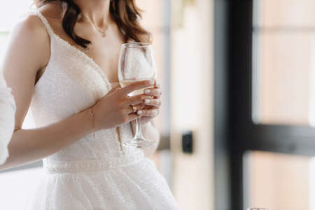 The bride holds a glass of champagne at the banquet. Close-up imageの写真素材