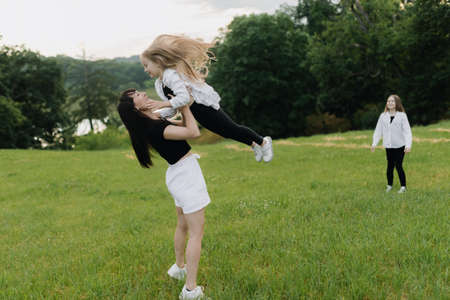 Mother and two daughters are playing in the park in summerの写真素材
