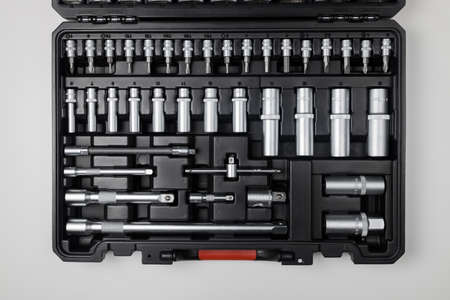 Wrenches of different sizes with different hex heads in a black box on a white table. View from...