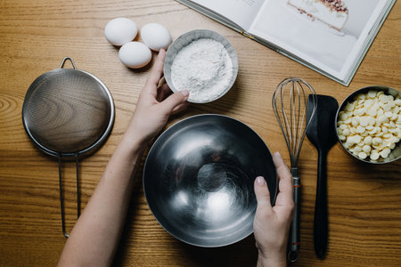 Female hands on table near ingredients and kitchen items for baking.の写真素材