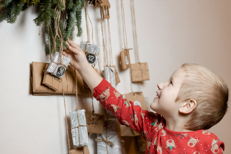 Smiling little boy close up taking gift from Advent calendar at home. Christmas traditionの写真素材