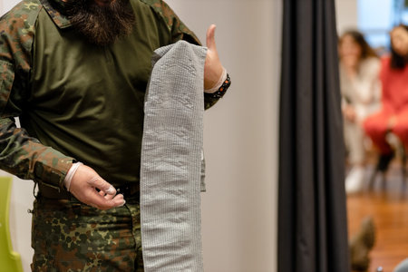 A combat medic demonstrates an unfolded bandage for dressing, close-up.の写真素材