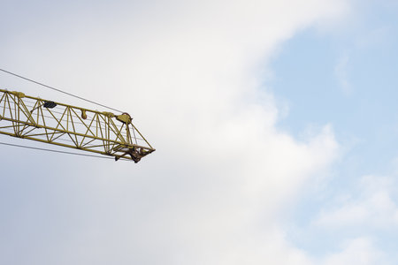 Part of a construction crane against a blue sky. Bottom view of an crane