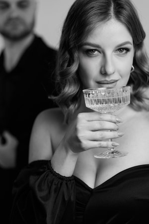 Black and white photo of a beautiful European woman with a glass of champagne in her hand. Honeymoon, Valentines Dayの写真素材