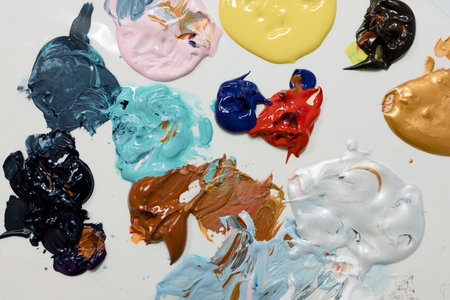 A flat surface showcasing a vibrant mix of paints, displaying a variety of colors and textures, fresh and glossy.の写真素材