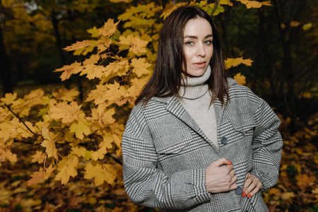 Serene Autumn: A Stylish Individual Amidst Fall Foliageの写真素材