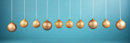 Elegant golden ornaments dangle from thin strings in a perfect row against a calming blue background. Their glimmer adds a festive touch, inviting warmth and joy to any celebration.の素材