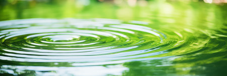 Gentle ripples cascade across a tranquil pool of green water, reflecting soft sunlight and surrounding foliage, creating a serene atmosphere filled with natural beauty and peace.の素材