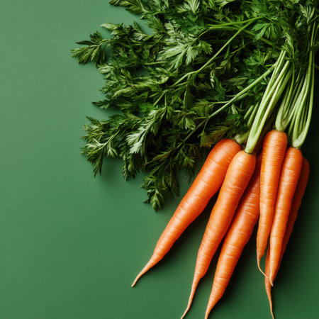 Bright and crisp carrots display their vivid orange hue, complemented by lush green leaves. This fresh bounty showcases natureの素材