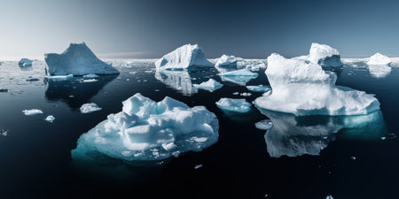 Floating ice formations create a stunning contrast against the calm ocean, reflecting the soft hues of early morning light in the Arctic. A serene moment in a chilly, pristine landscape.の素材