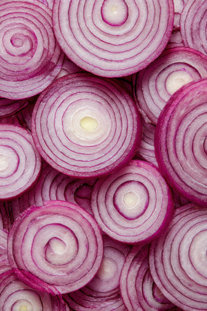 A stunning top-down view features red onion rings in a mesmerizing concentric pattern, blending shades of purple and white. The neutral tones enhance their natural beauty and detail.の素材
