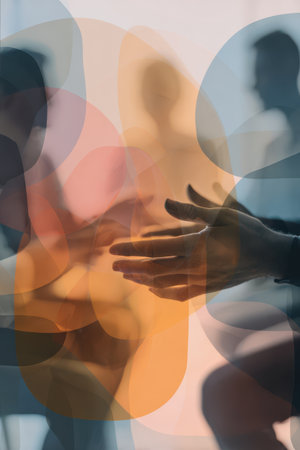 Hands engage in animated conversation amidst a backdrop of colorful abstract shapes, creating an energetic atmosphere of collaboration.の素材