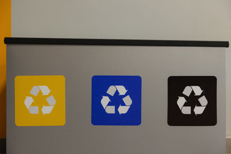 Colorful recycling bins stand in a contemporary office, encouraging waste separation and...