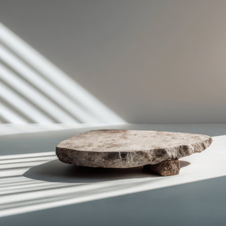 A unique stone table rests on a smooth surface, illuminated by soft light and creating delicate shadows in a serene space.の素材