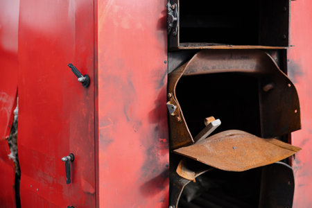 A red boiler unit stands tall in a manufacturing facility, showcasing details of its design and engineering.の写真素材