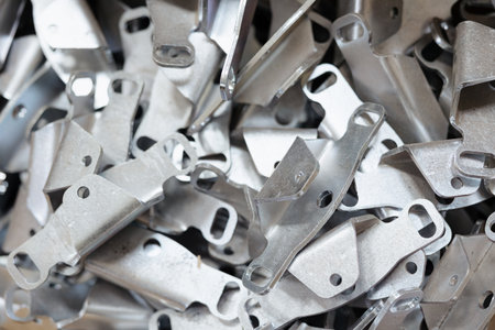 A close view of numerous shiny metal pieces piled high, illustrating the intricate process of boiler production.の写真素材