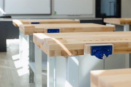 Bright workspace features sturdy wooden workbenches, perfect for hands-on learning and creativity in...