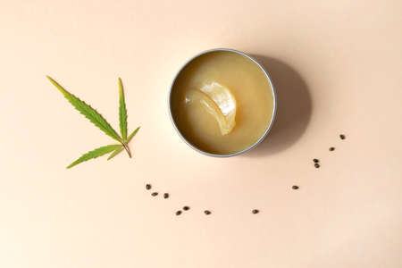 Hemp salve with cannabis leaves on powdery beigeの写真素材