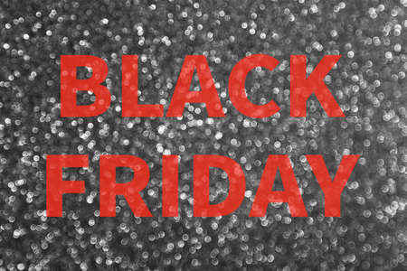 Black brilliant glitter shine background texture close up, inscription black friday red letters. Black Friday pre-holiday shop and sale concept. Flyer shopping, online sale. Screensaver for the site.の写真素材