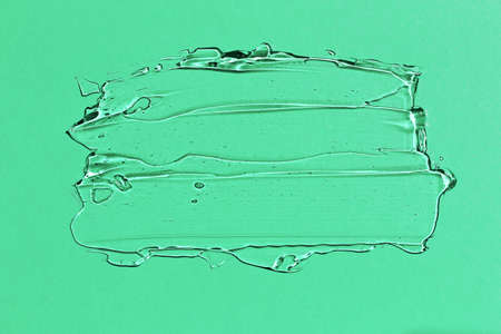 Transparent pure aloe vera gel on light green paper background cosmetic serum moisturizing top view, closeup. Place for text.の写真素材