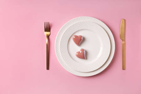 Festive table setting for valentine's day or wedding anniversary white plate and pink heart decor...