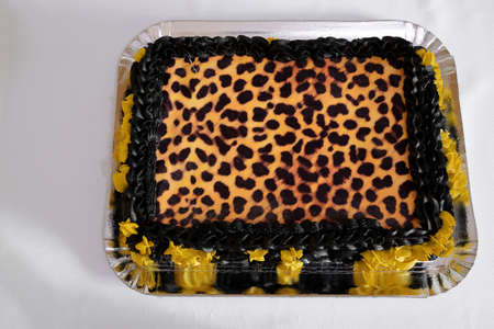Creative sweet cake decorated with leopard print and black and yellow detailsの写真素材