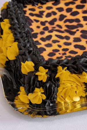 Creative sweet cake decorated with leopard print and black and yellow detailsの写真素材